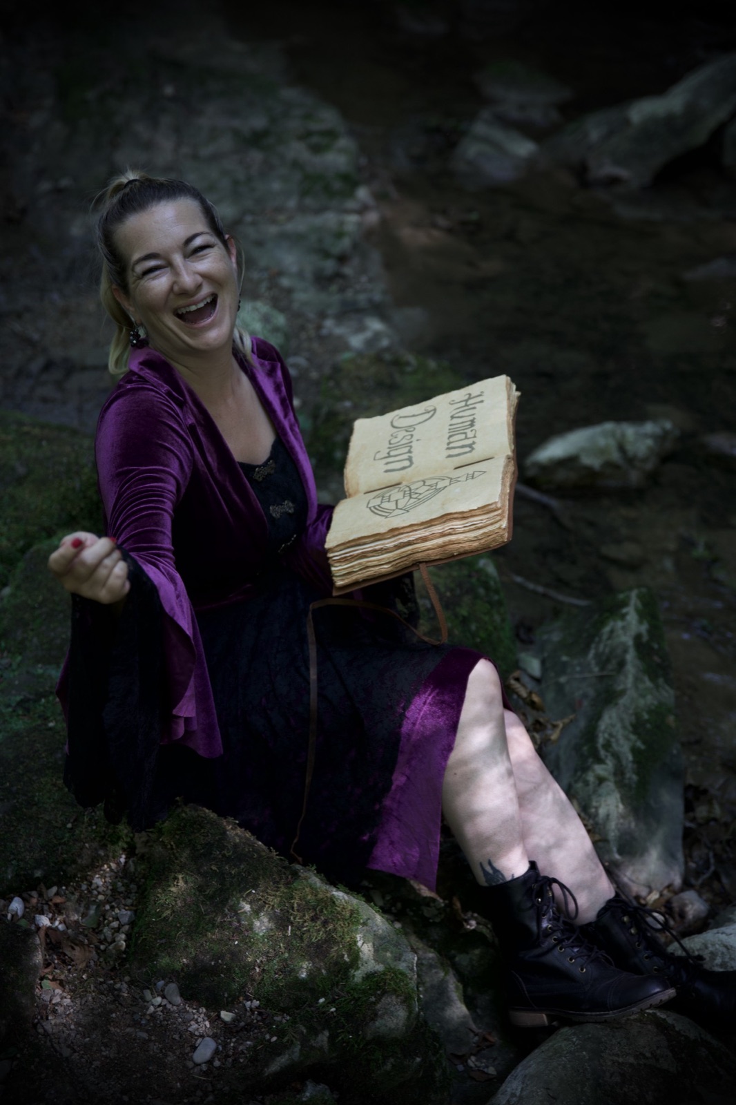 Katrin Hager lacht mit dem Human-Design-Buch im Wald